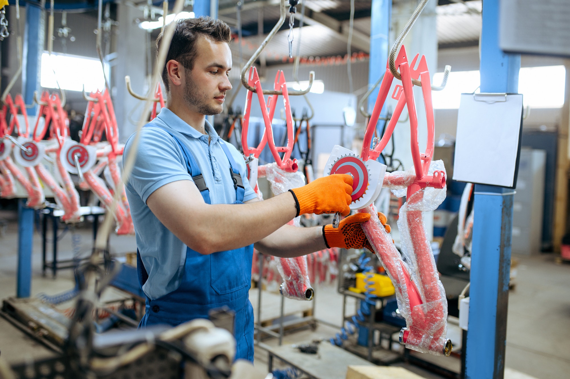 Bicycle factory, worker holds kid's bike frame