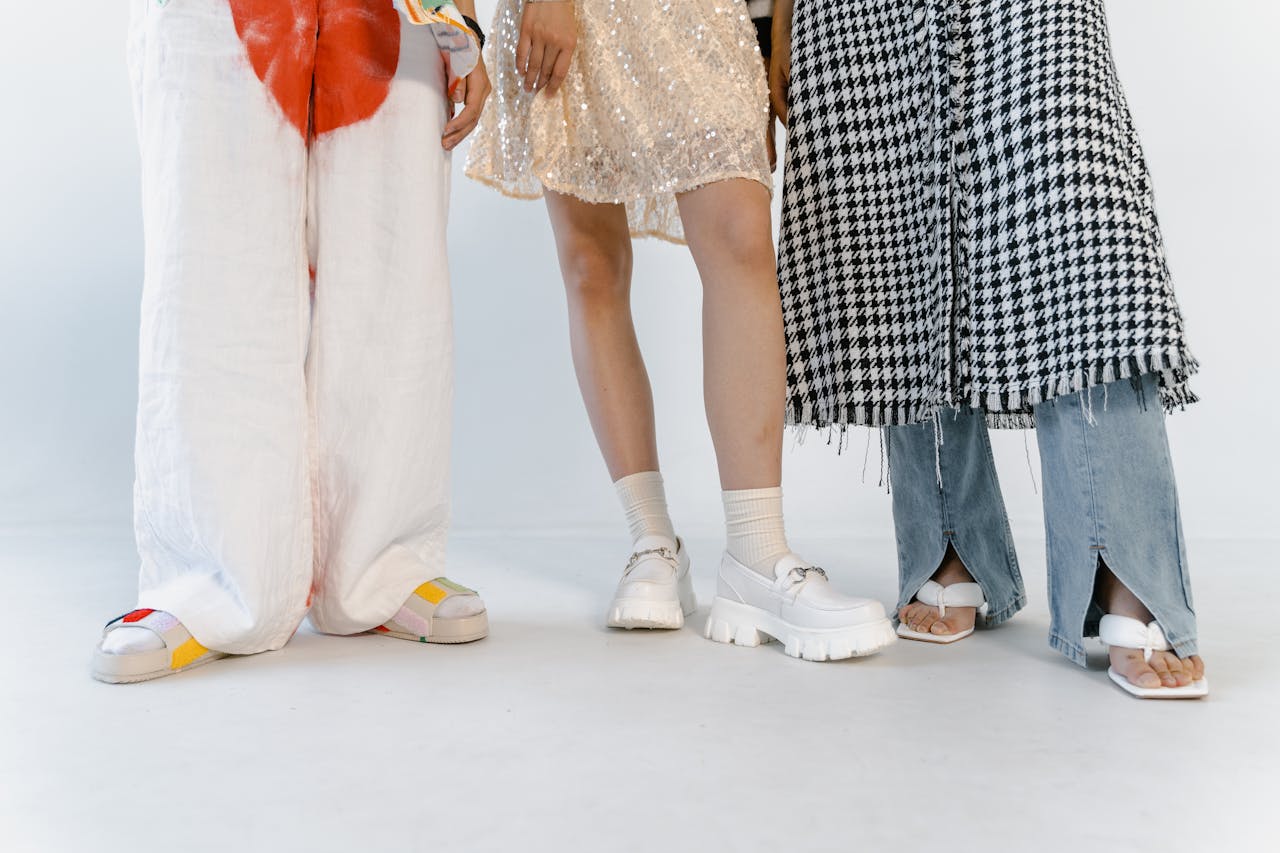 Explore diverse fashion looks featuring stylish pants, skirts, and trendy footwear in a studio setting.